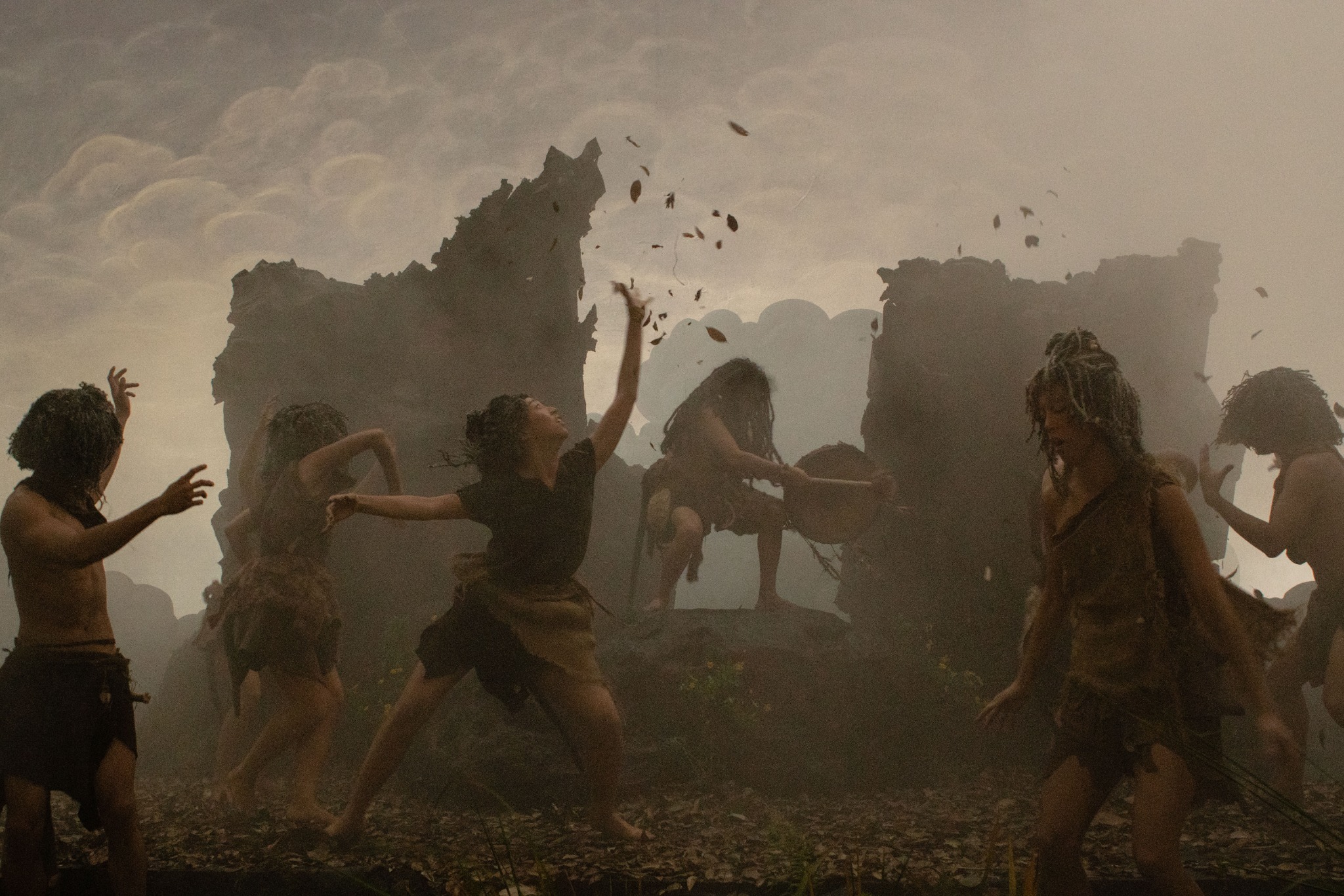 Film still from Ancestor’s Fuxi: members of the ancestral community dancing in a misty clearing among sculpted rock formations.