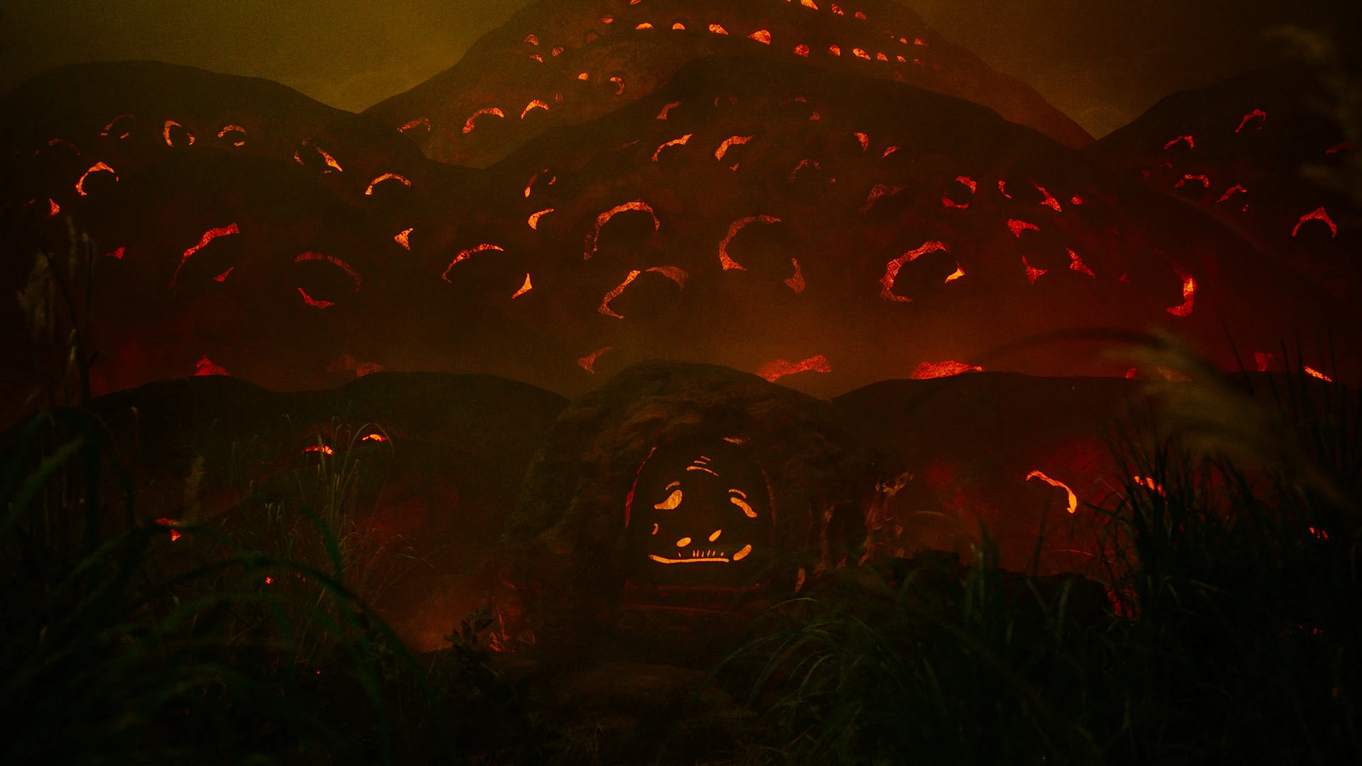 Film still of an ancient landscape glowing with amber firelight