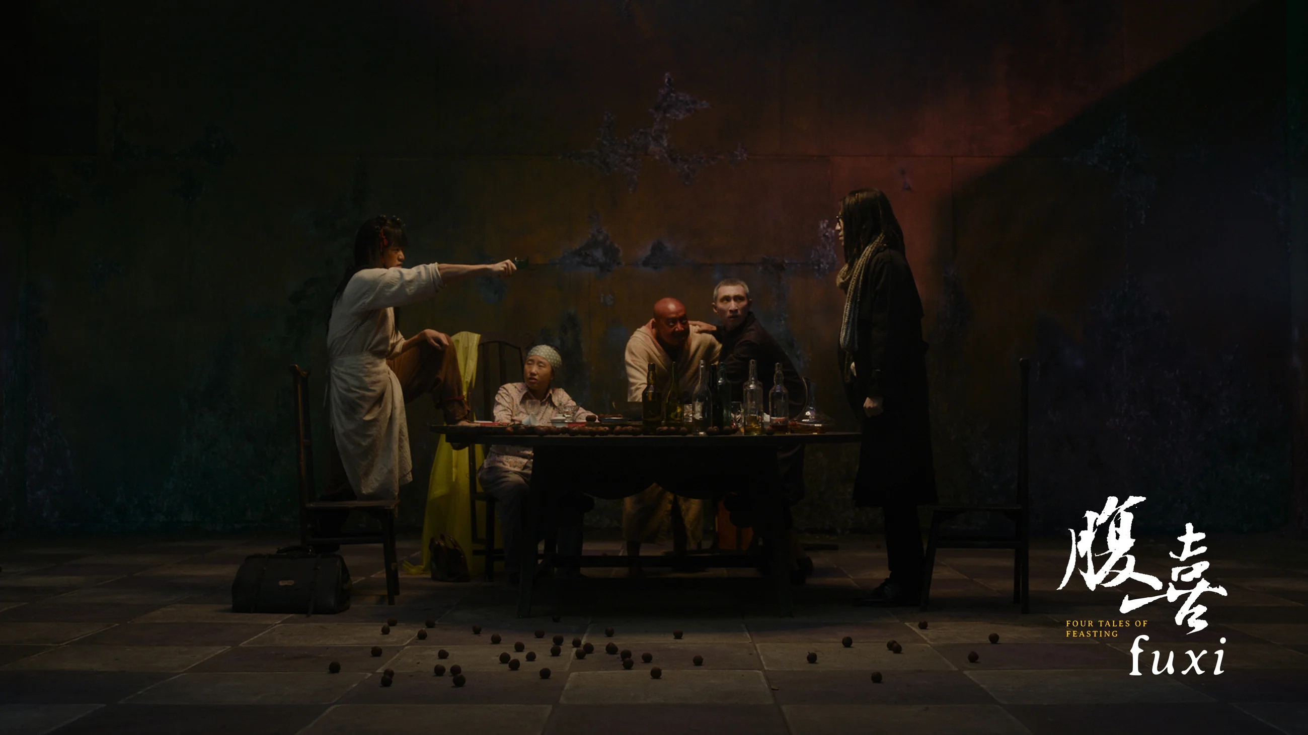 FUXI film still of a group gathering around a table in a dark theatrical setting
