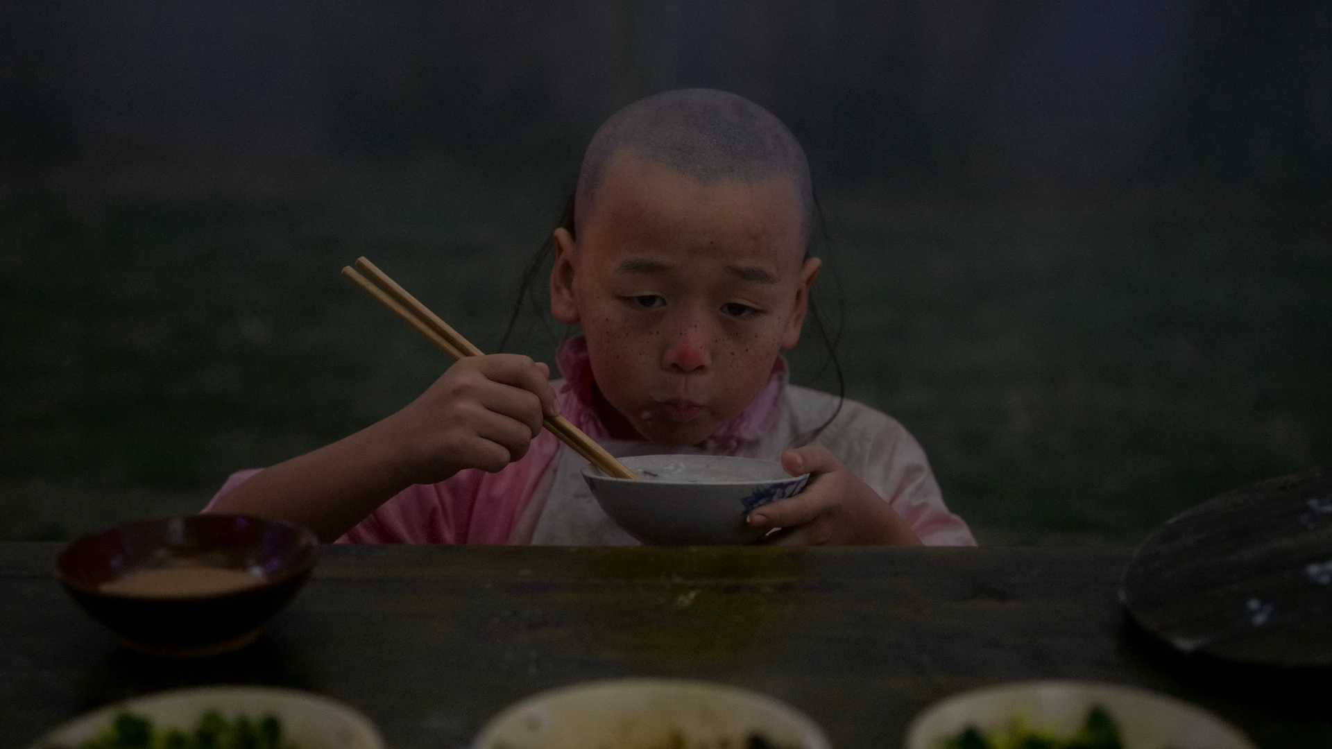 Film still: Zhang Sanxing eating fish congee at the birthday feast